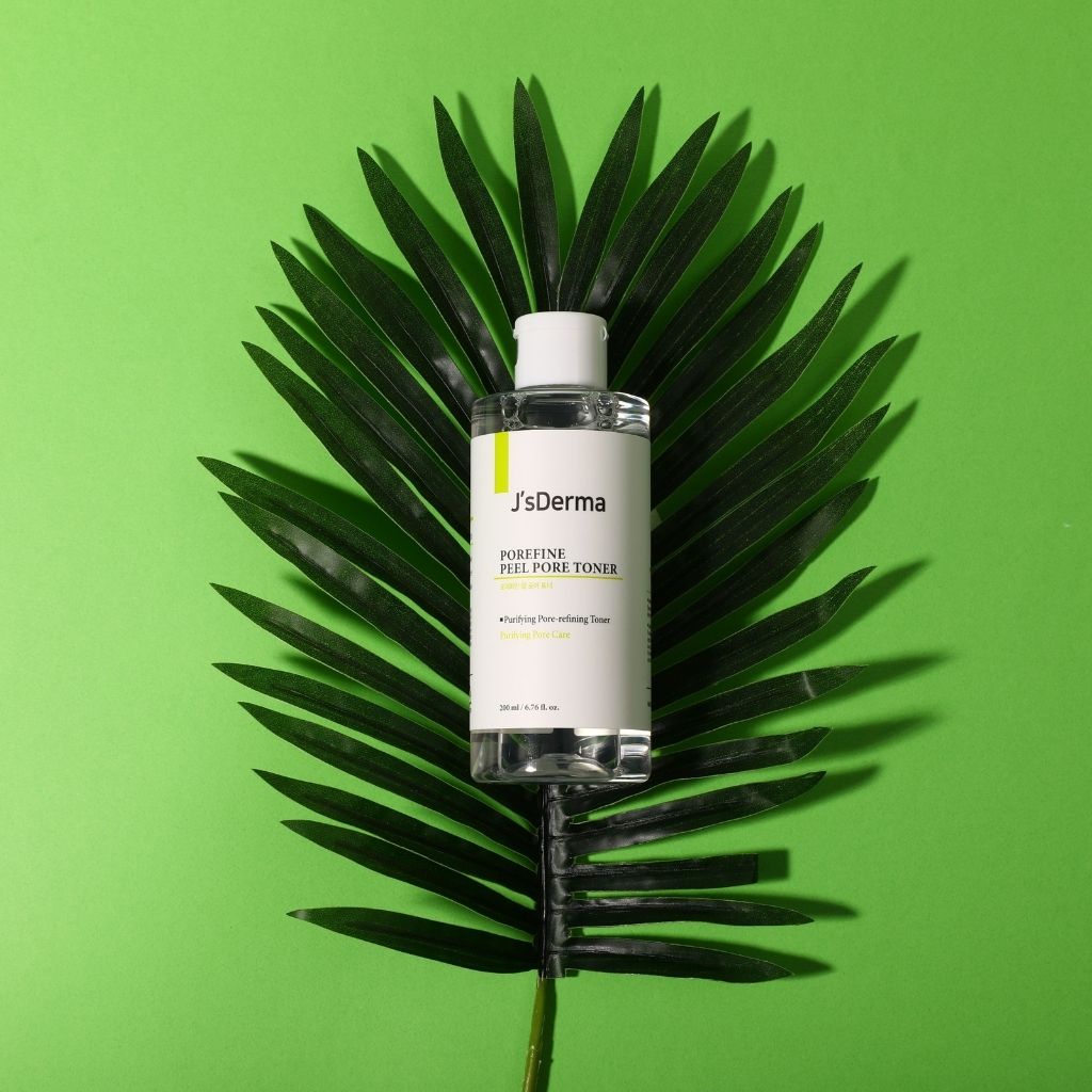 JsDerma toner bottle on a large green leaf against a green background