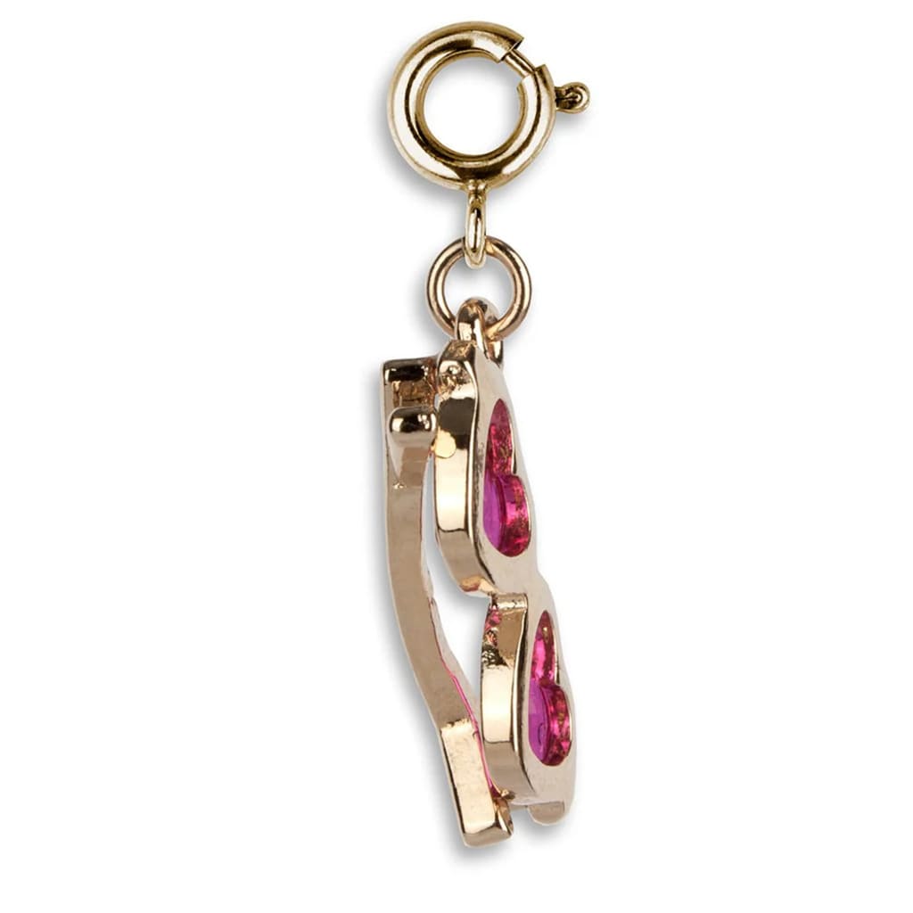 Gold and pink nail clipper charm on a white background