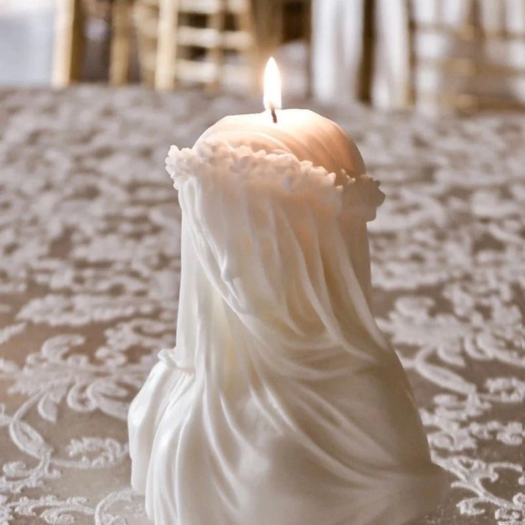 Candle in a decorative holder with lace on a textured surface