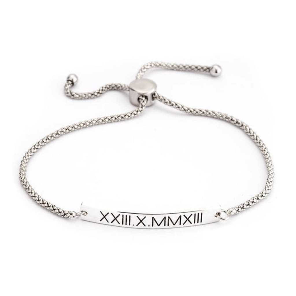Silver bracelet with Roman numeral engraving on a white background