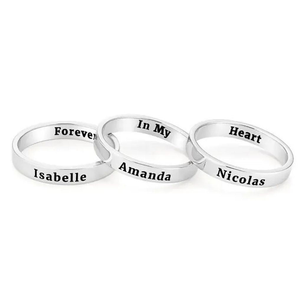 Three silver rings with engraved names on a white background