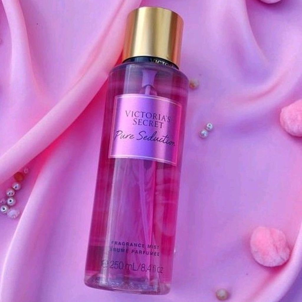 Victoria's Secret Pure Seduction fragrance mist bottle on a pink fabric background