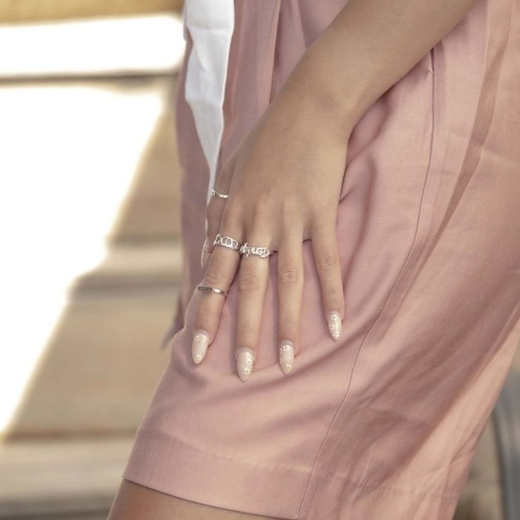 Close-up of a hand with multiple rings on a blurred background