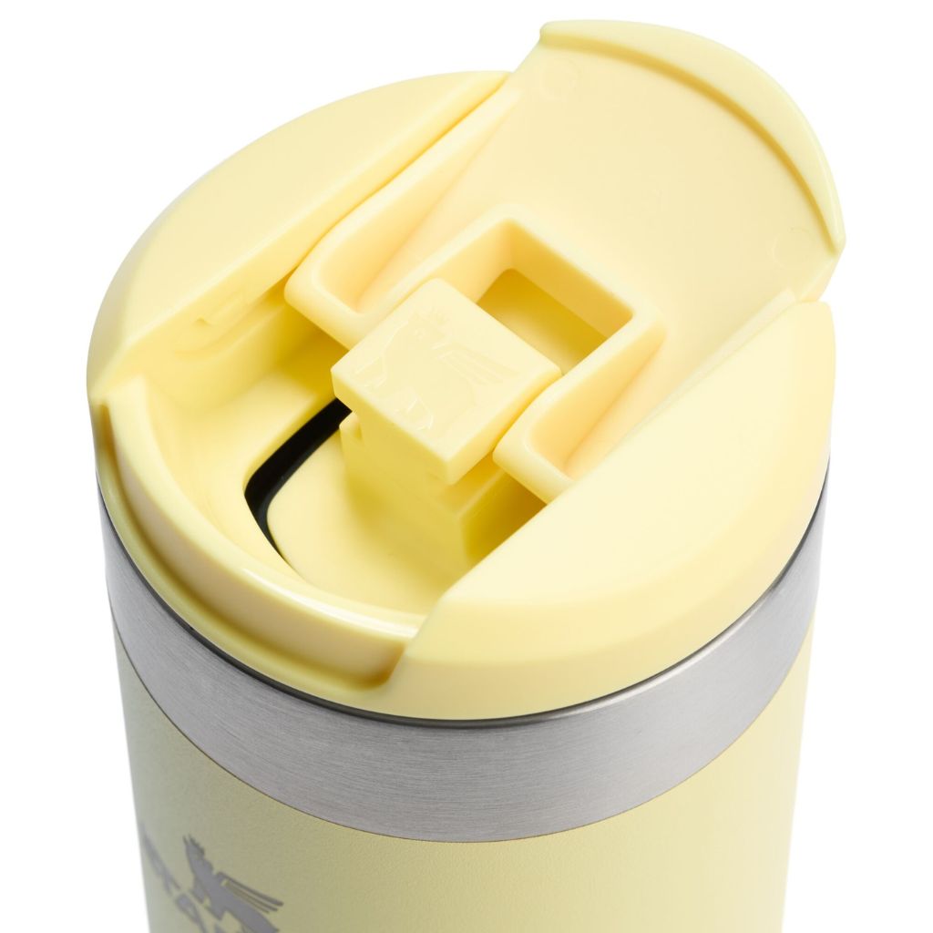 Close-up of a yellow insulated mug with a silver base on a white background