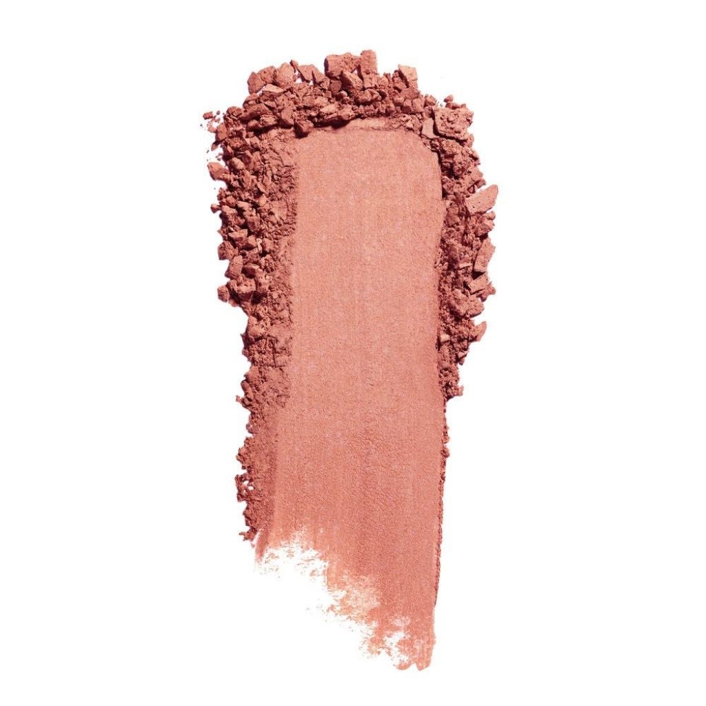 Nude-colored makeup swatch with crumbly texture on a white background