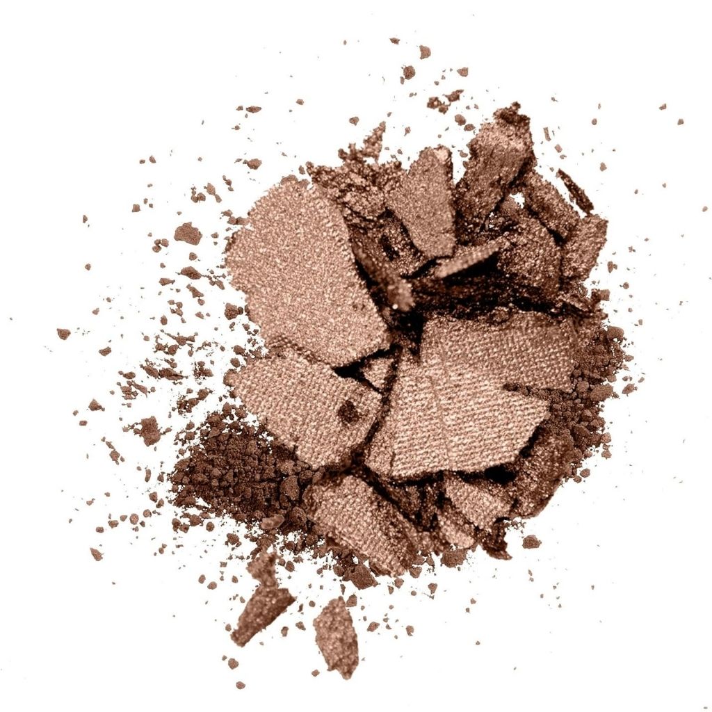 Shattered brown makeup powder on a white background