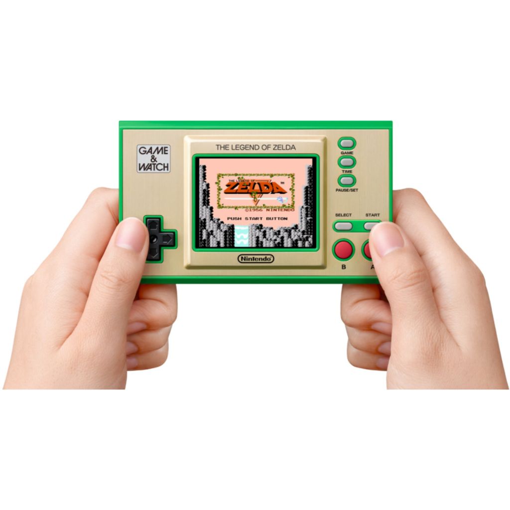 Handheld gaming console with 'The Legend of Zelda' display held by two hands on a white background