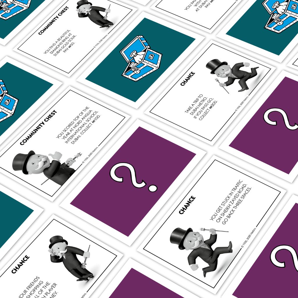 Close-up of Monopoly game cards with various icons and text.