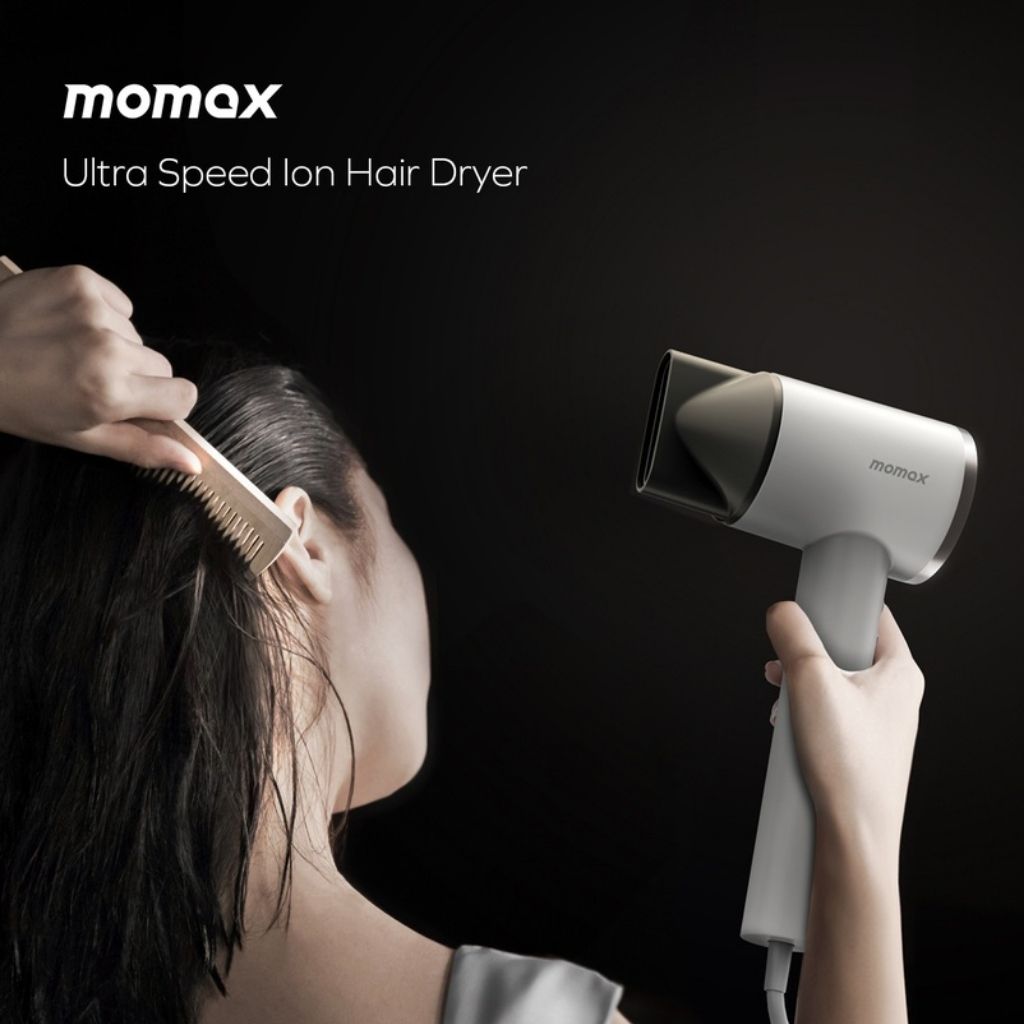 Person using a Momax ultra speed ion hair dryer on their hair with a black background