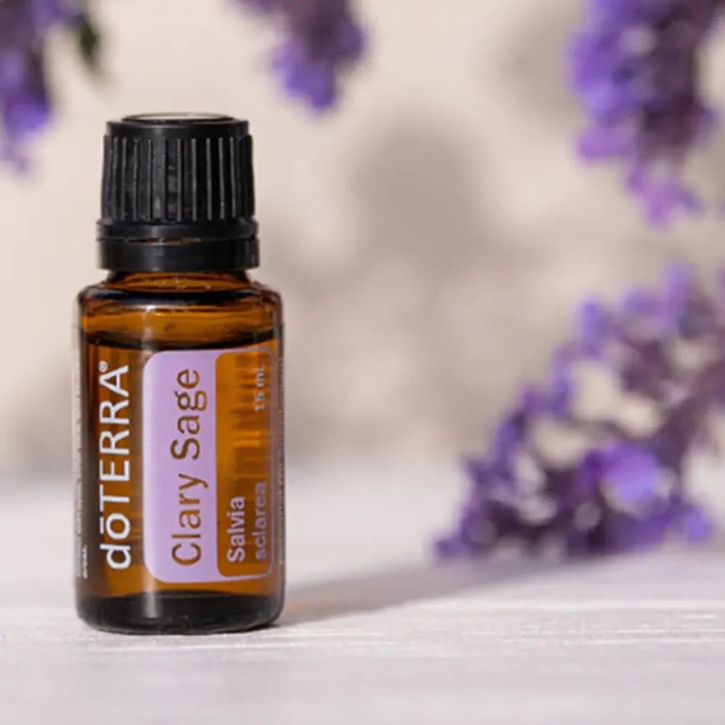 doTERRA Clary Sage essential oil bottle with blurred purple flowers in the background