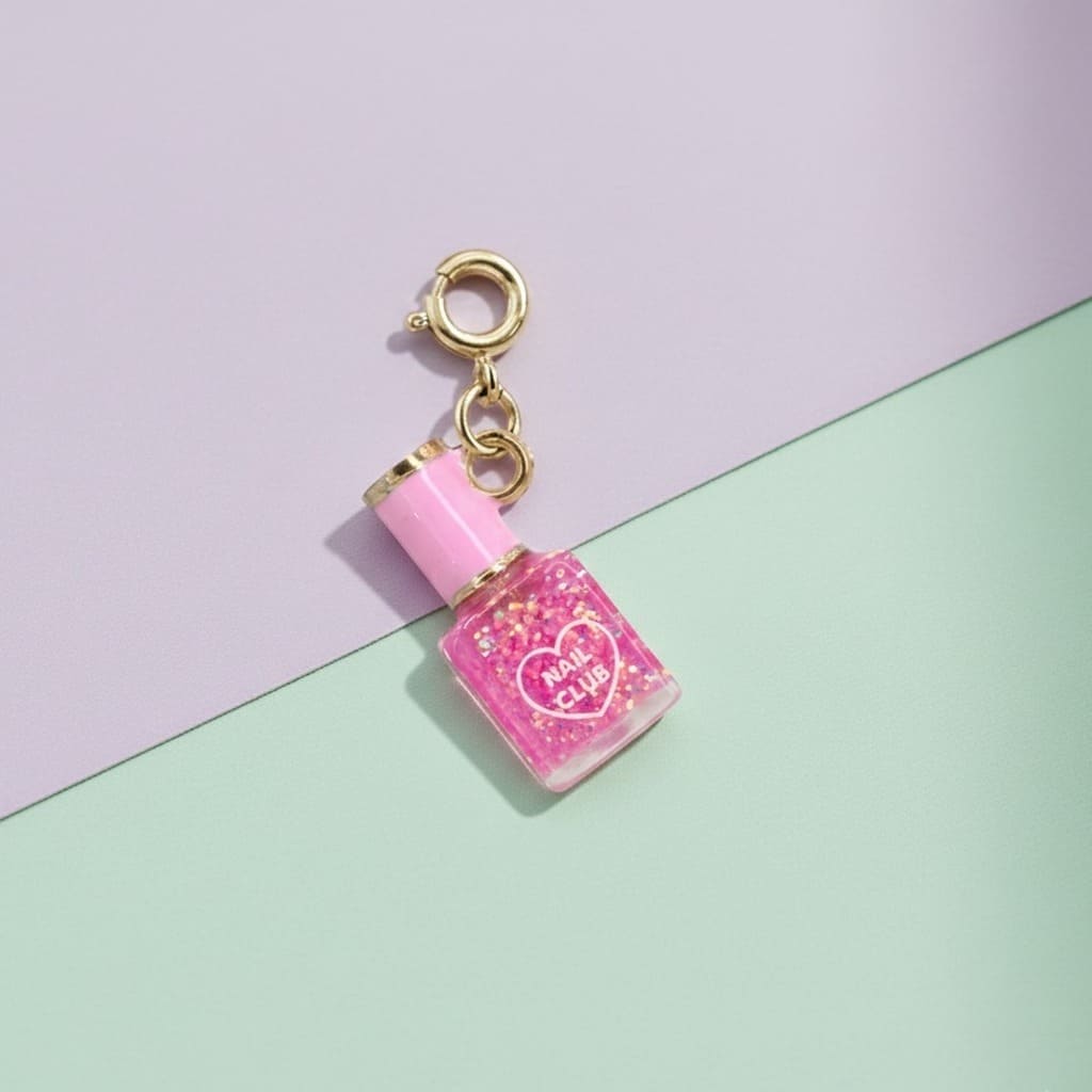 Pink nail polish charm with gold top on a pastel background