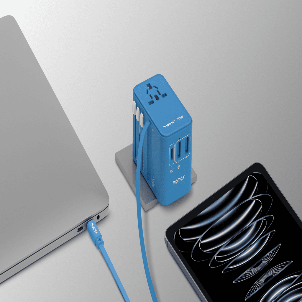 Blue travel adapter with multiple ports next to a laptop and smartphone on a light gray background