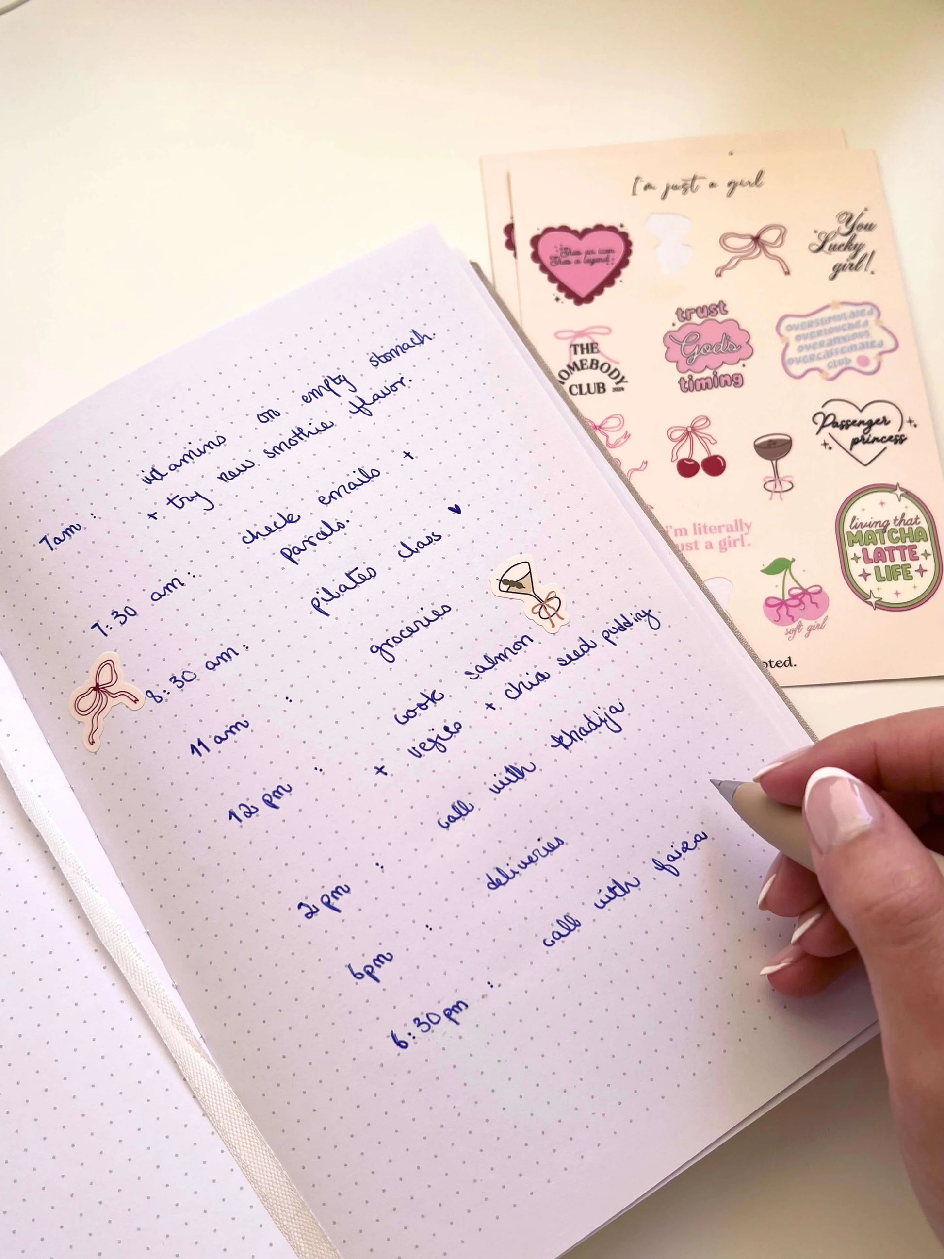 Handwritten notes in a notebook with decorative stickers on a light background