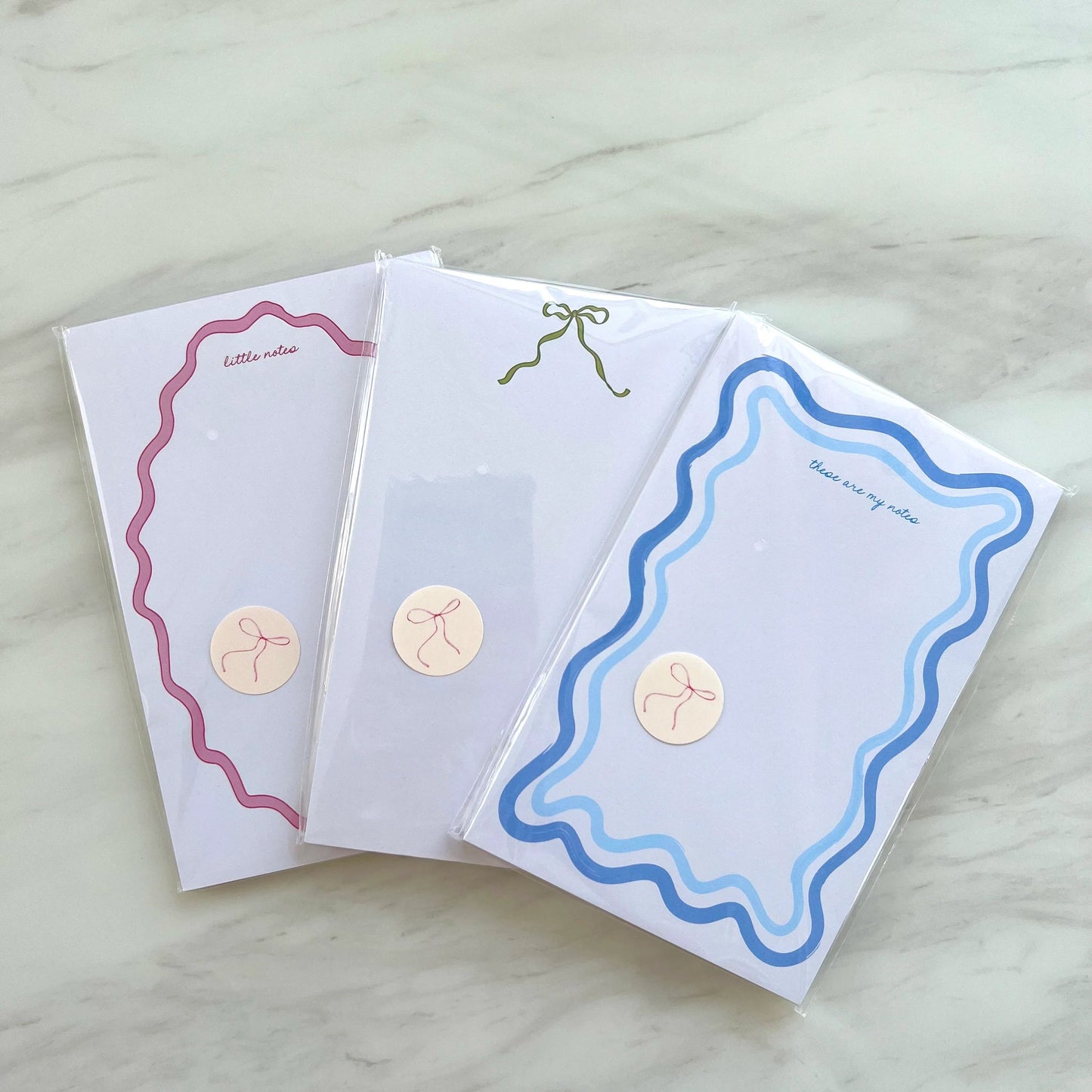 Three decorative greeting cards with different designs on a light wooden surface.