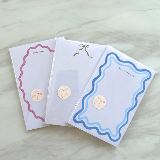 Three decorative greeting cards with different designs on a light wooden surface.