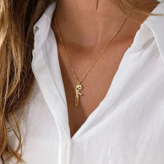Gold necklace with a pendant on a person wearing a white shirt