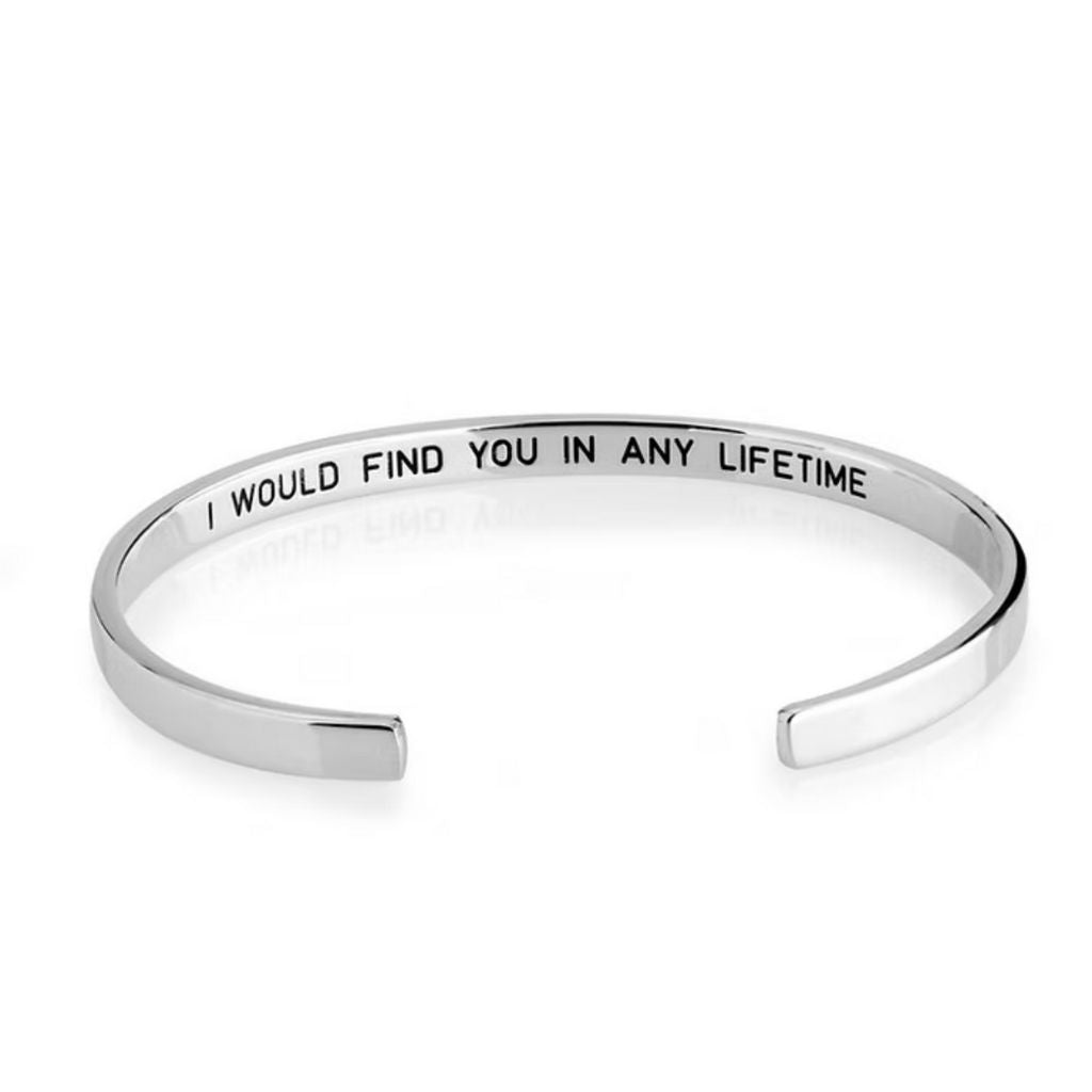 Silver bracelet with engraved message on a white background