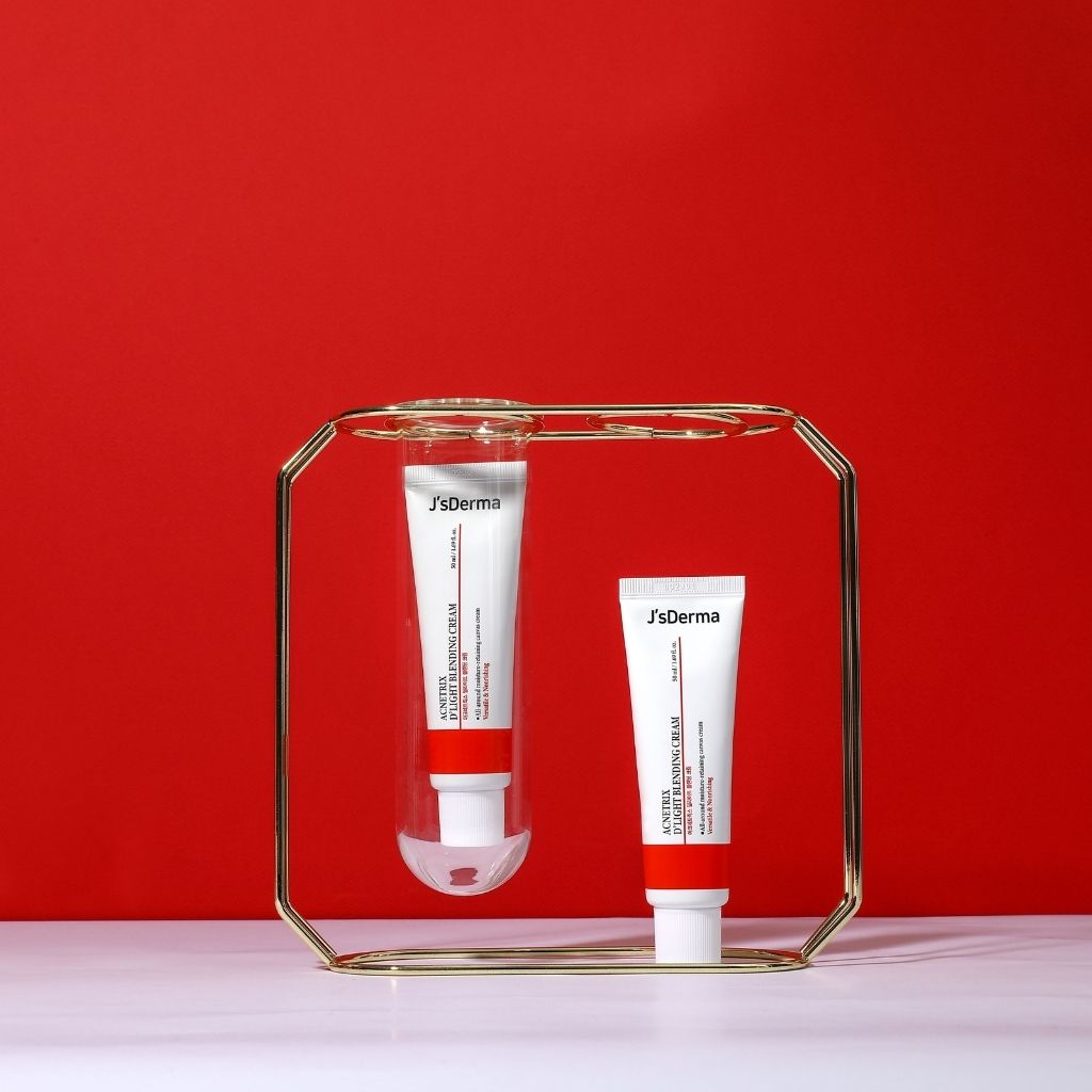 Two JsDerma skincare products on a gold stand against a red background