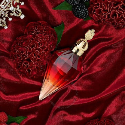Red and gold perfume bottle on a red fabric background with berries and flowers.