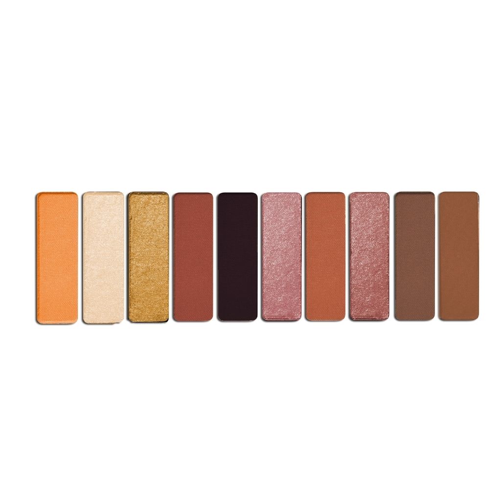 Row of makeup eyeshadow pans in various colors on a white background