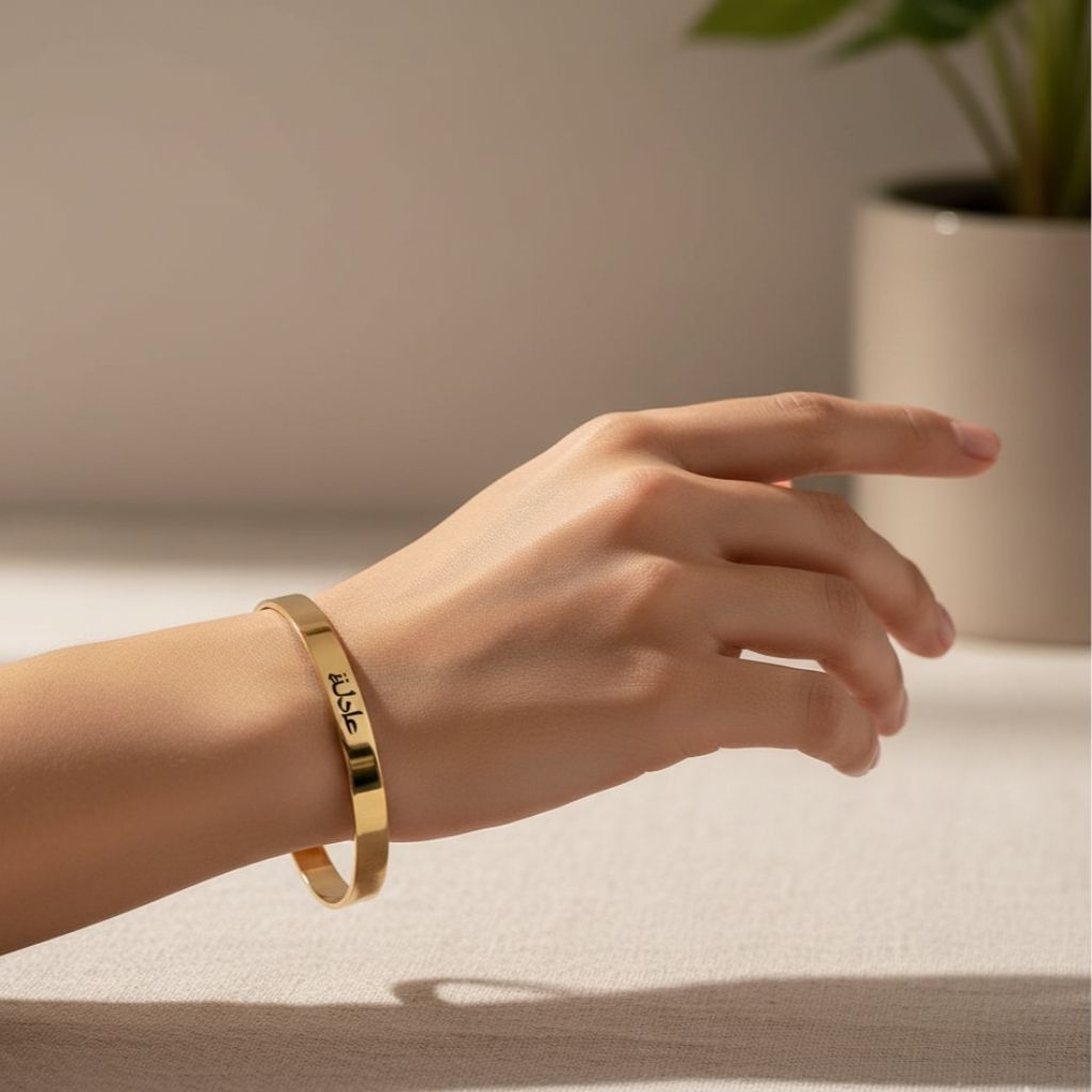 Gold bracelet on a hand with a neutral background