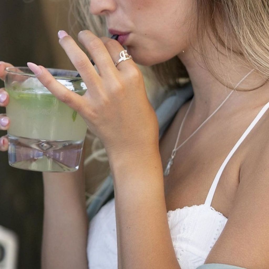 Woman drinking a cocktail with a blurred background