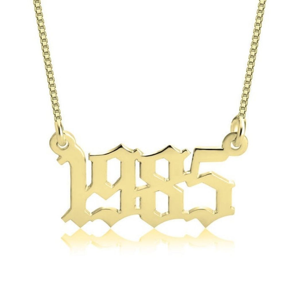 Gold '1985' necklace on a white background