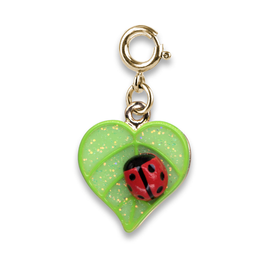 Gold charm with a red ladybug on a green leaf against a white background