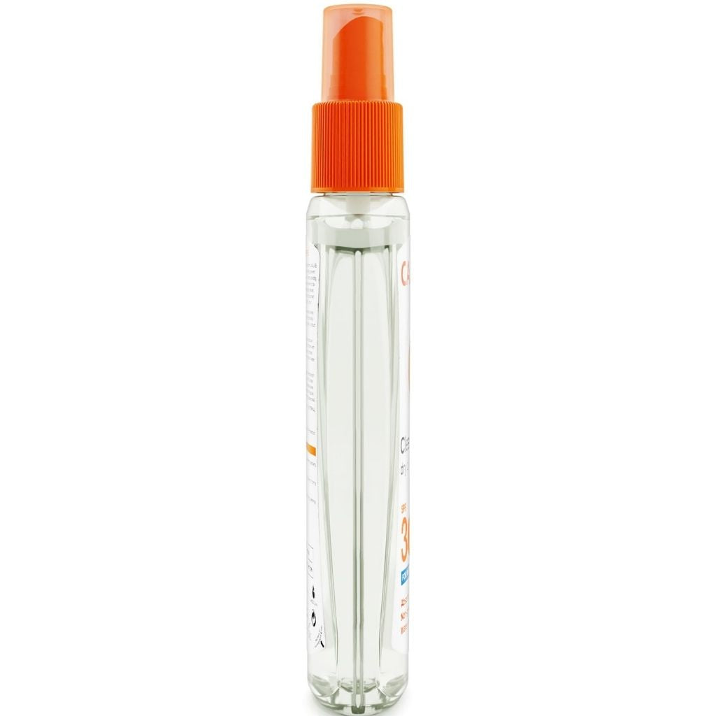Clear spray bottle with an orange cap on a white background