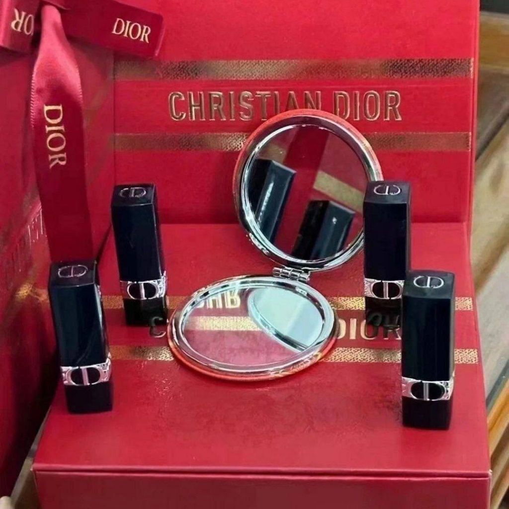 Christian Dior makeup set with lipsticks and a compact mirror on a red Dior box.