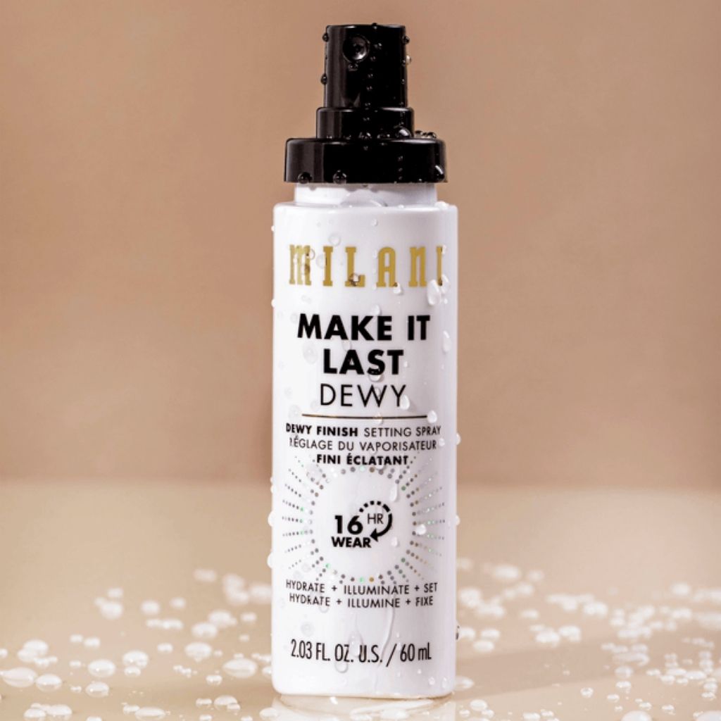 Milani Make It Last Dewy setting spray bottle on a beige background