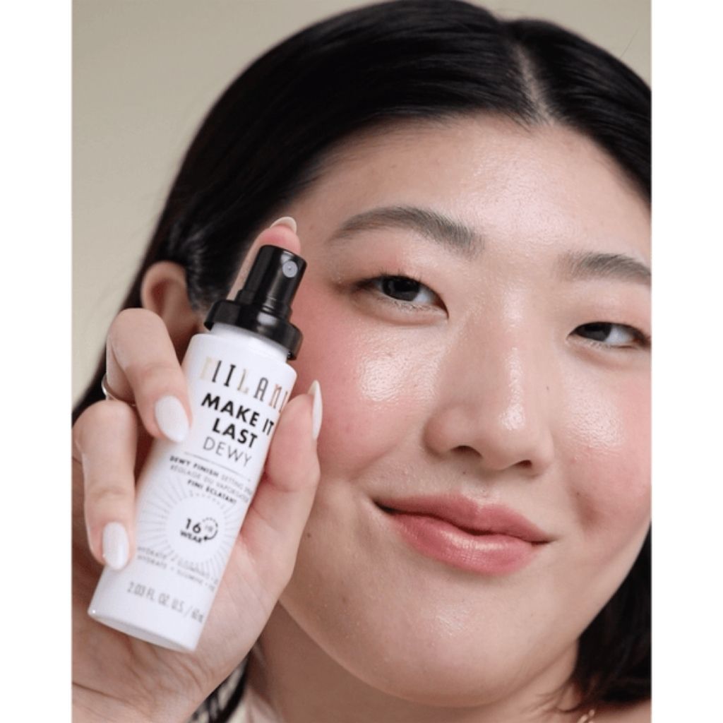 Woman holding a skincare product labeled 'MAKE IT LAST' near her face.