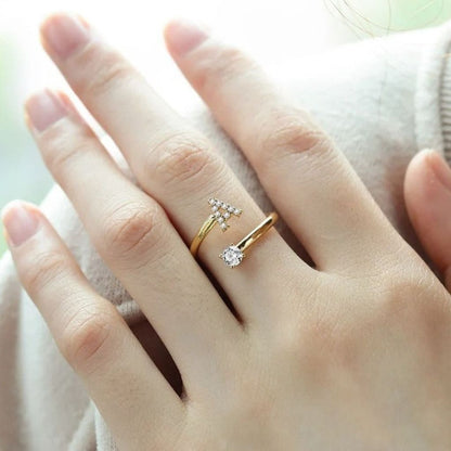 Hand wearing two gold rings with diamond accents on a blurred background