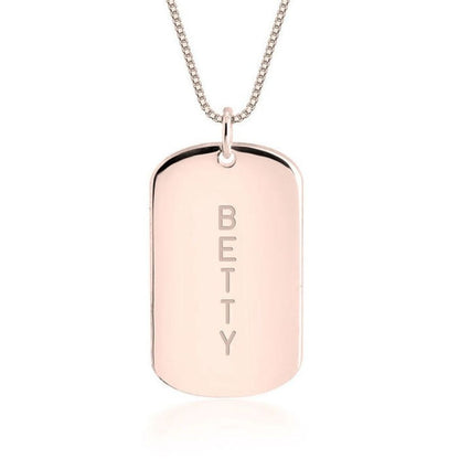 Rose gold dog tag necklace with 'BETTY' engraving on a white background