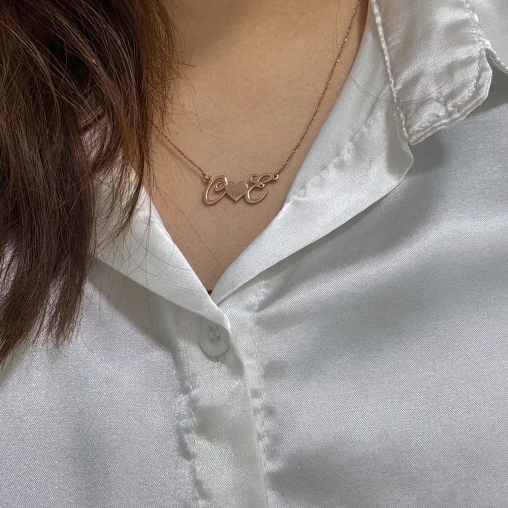 Necklace with 'LOVE' pendant on a white shirt