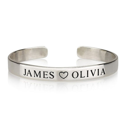 Silver bracelet with 'JAMES ❤️ OLIVIA' engraved on a white background