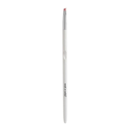 White makeup brush with red bristle tip on a white background