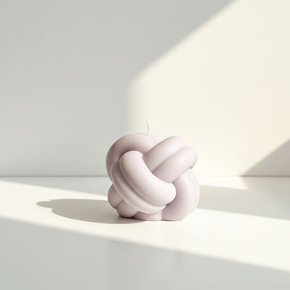 Decorative knot sculpture on a light surface with soft shadows