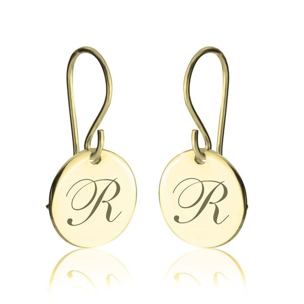 Gold earrings with 'R' engraving on a white background