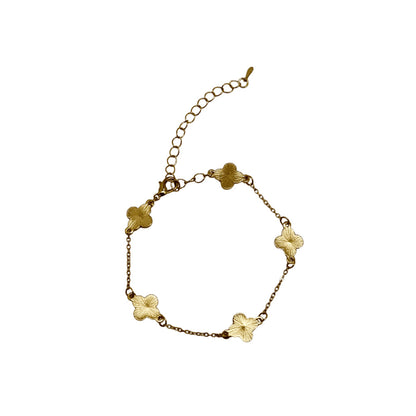 Gold bracelet with floral designs on a white background