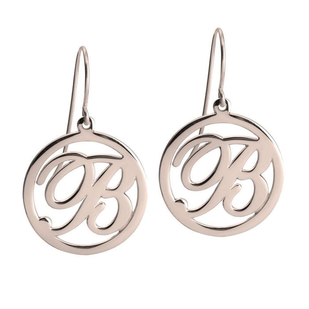 Silver earrings with monogram design on a white background