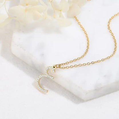 Gold necklace with a heart-shaped pendant on a white background