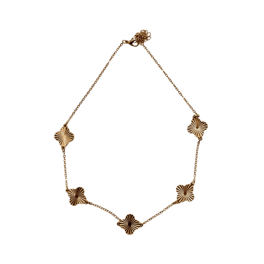 Gold necklace with floral links on a white background