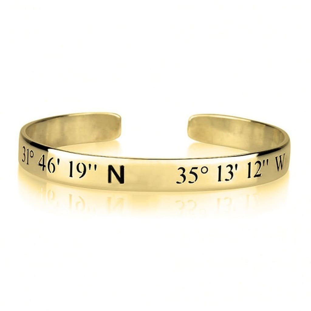 Gold bracelet with engraved coordinates on a white background