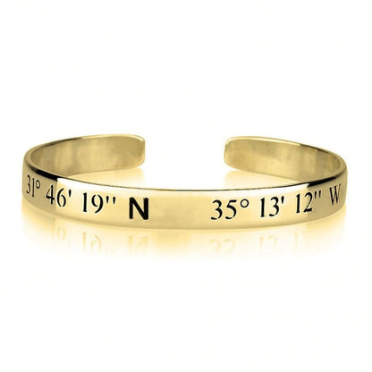 Gold bracelet with engraved coordinates on a white background