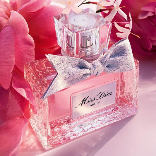 Miss Dior parfum bottle with a bow on pink flowers