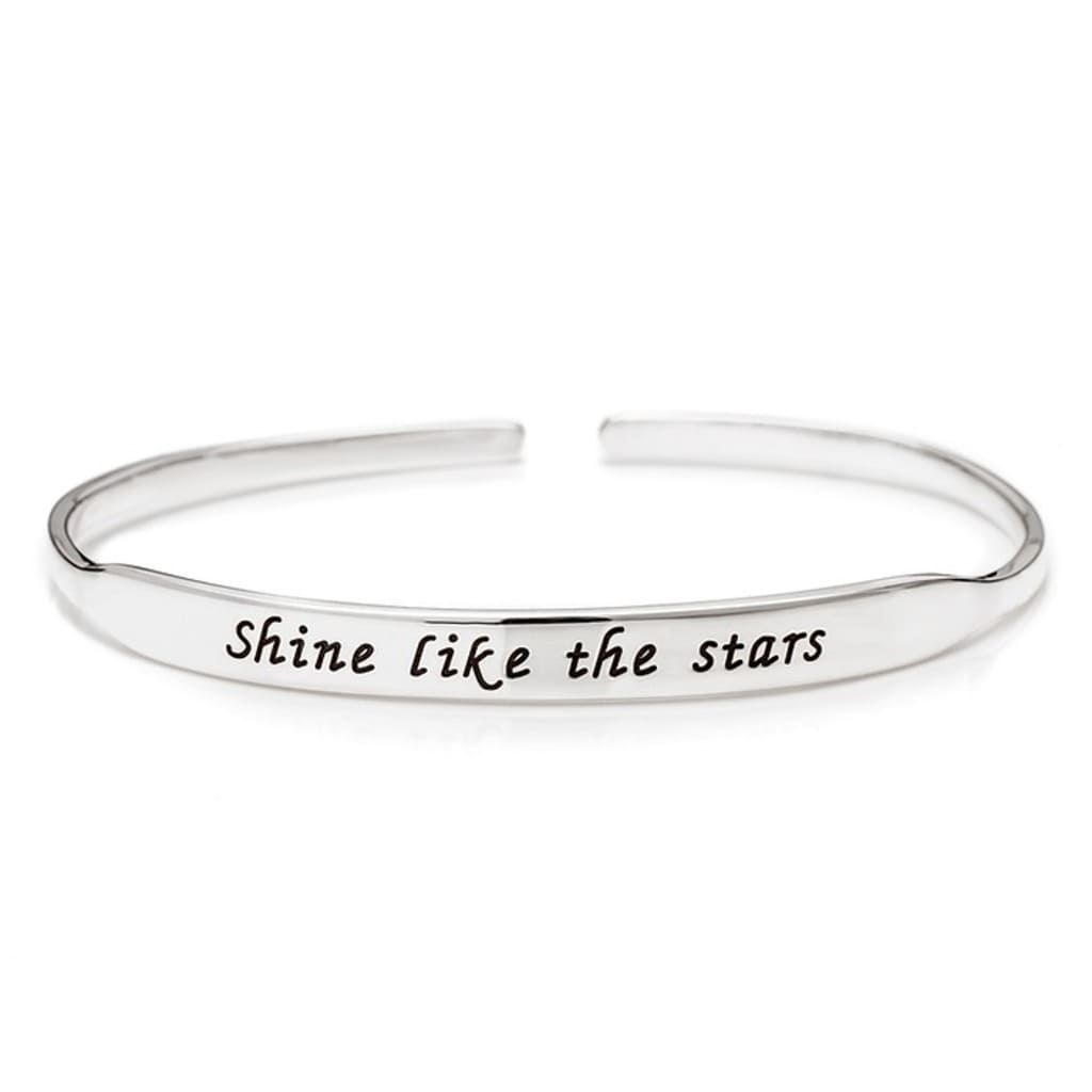 Silver bracelet with 'Shine like the stars' engraving on a white background