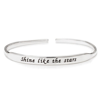 Silver bracelet with 'Shine like the stars' engraving on a white background