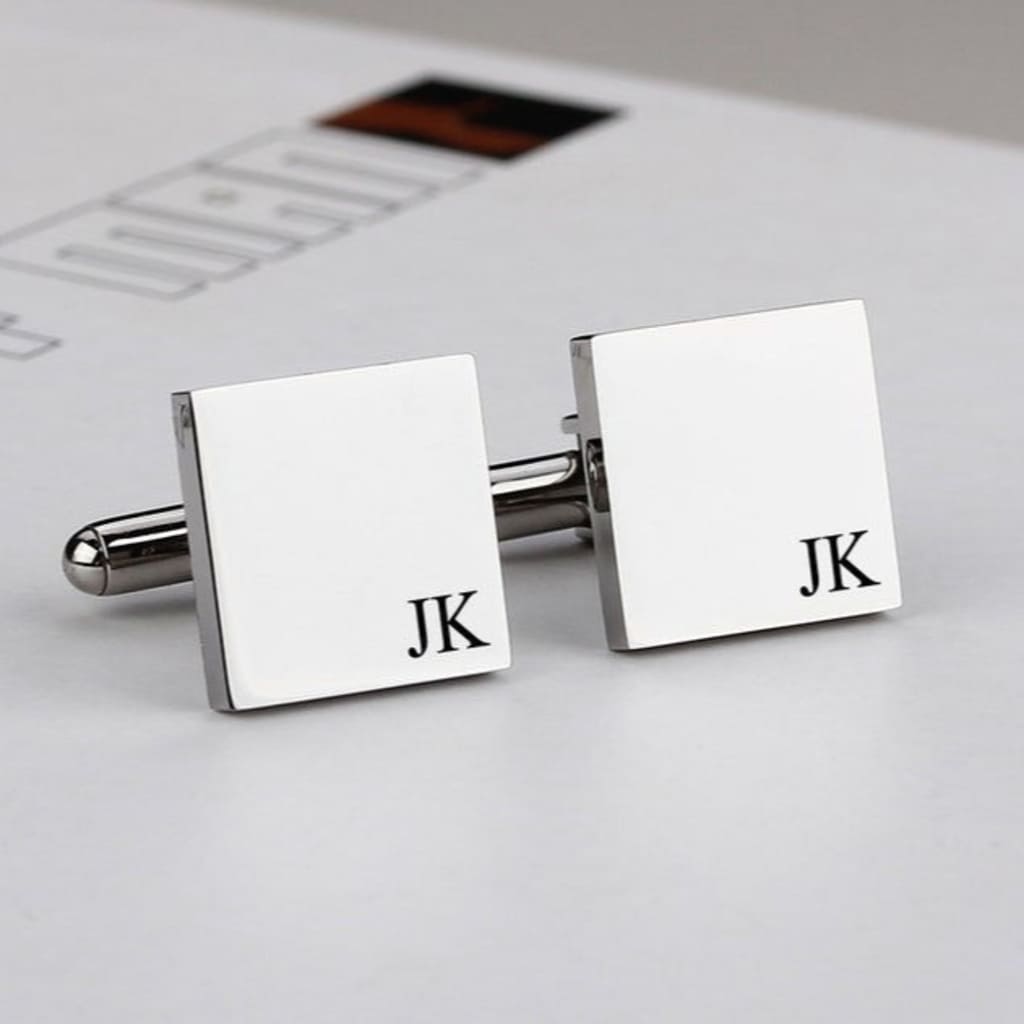 Silver cufflinks with 'JK' initials on a light background