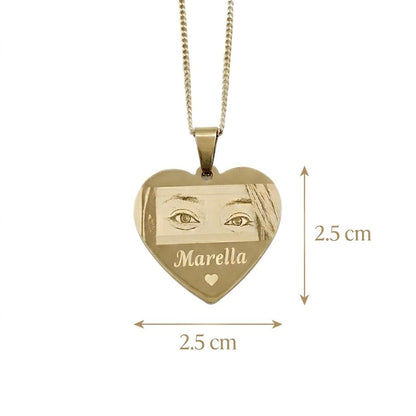 Gold heart-shaped pendant with engraved face and 'Marella' text, shown with measurements on a white background.